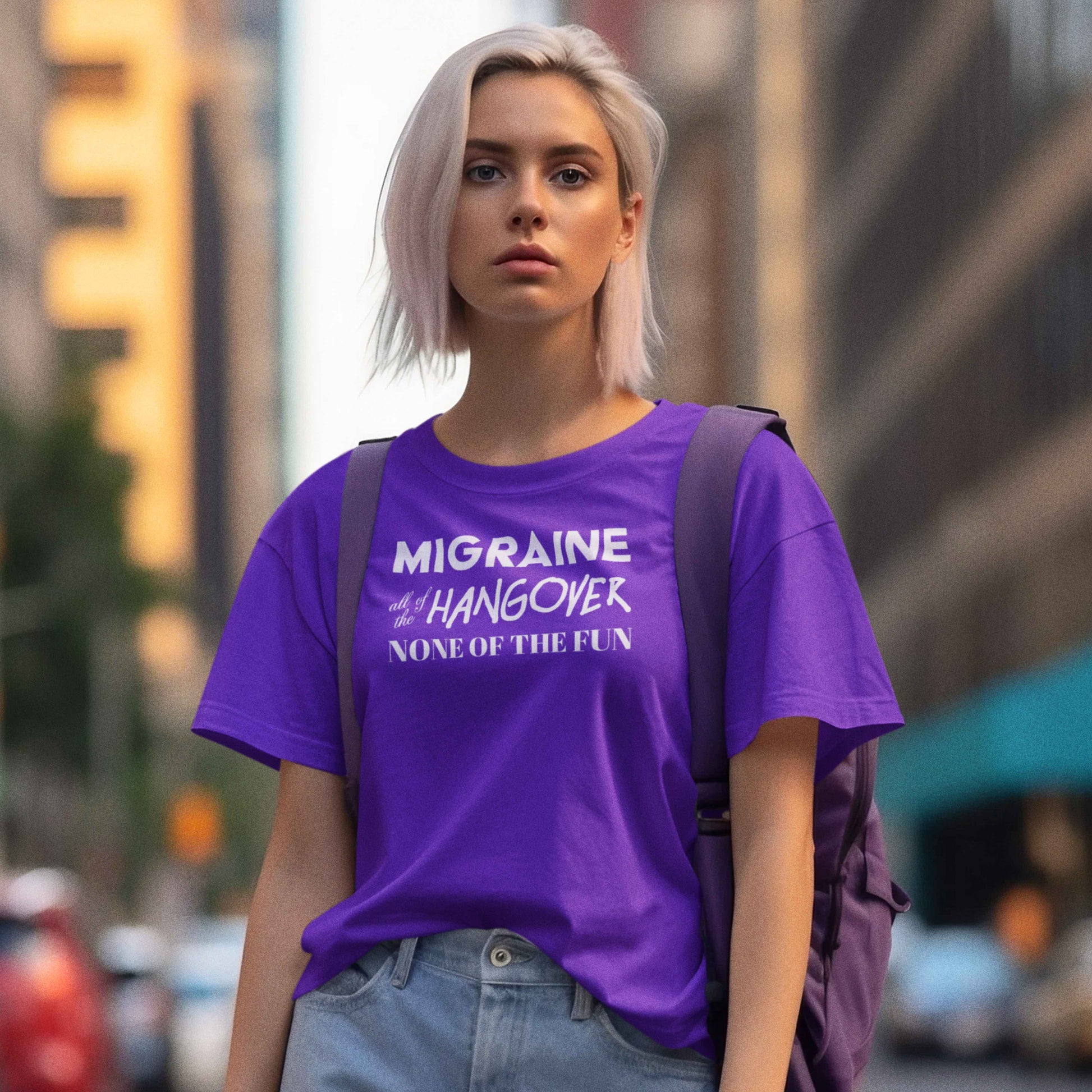 Woman with purple tshirt that says "Migraine all of the Hangover None of the Fun"